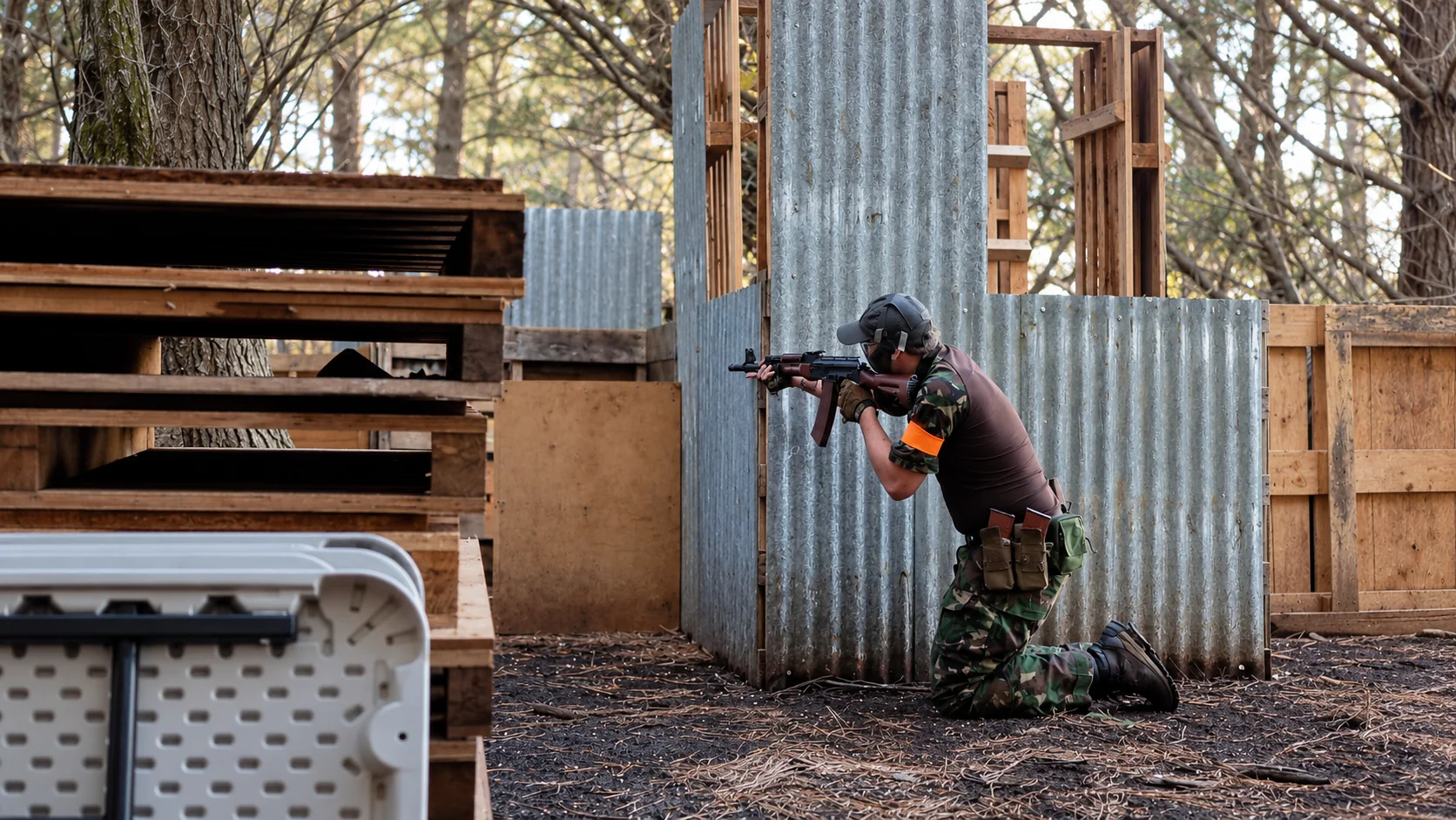Airsoft player using a field structure for cover